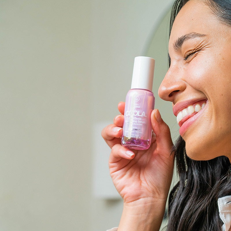 Women smiling holding the Dew Good Illuminating Serum