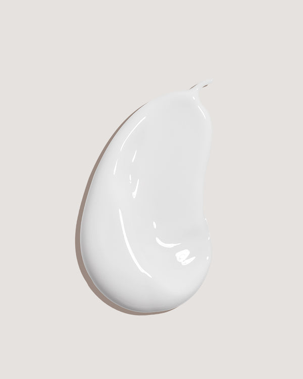 COOLA body sunscreen lotion formula swatch against neutral background