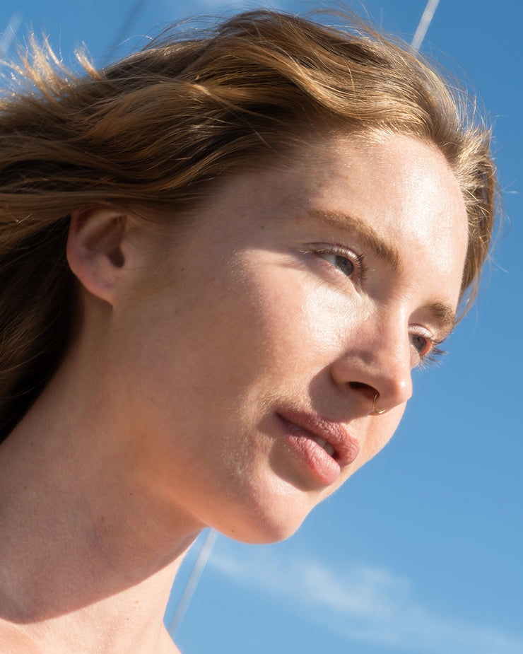 Woman's face with moisturized skin and blue sky background
