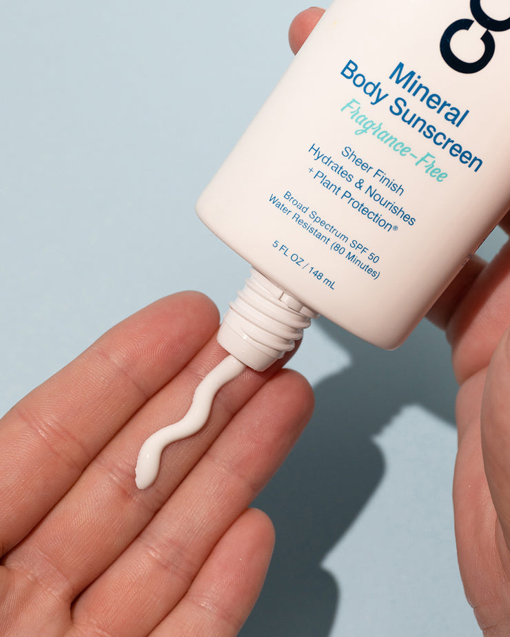 Close-up of COOLA Mineral Body Sunscreen Fragrance-Free dispensing in hand