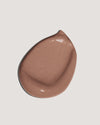 Light brown formula swatch of tinted moisturizer sunscreen on neutral background
