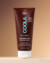Sunless Tan Firming Lotion sitting on counter against tan background.
