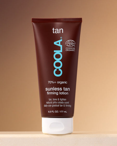 Sunless Tan Firming Lotion sitting on counter against tan background.