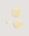 COOLA Sunless Tan Anti-Aging Face Serum formula drops on beige background.