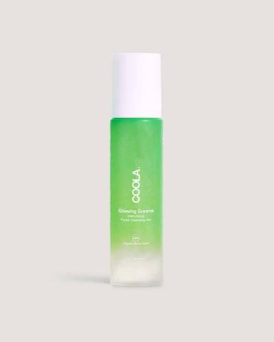 A bottle of COOLA Glowing Greens Detoxifying Facial Cleansing Gel against neutral background.