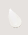 COOLA Sunless Tan Anti-Aging Face Moisturizer formula swatch on beige background.