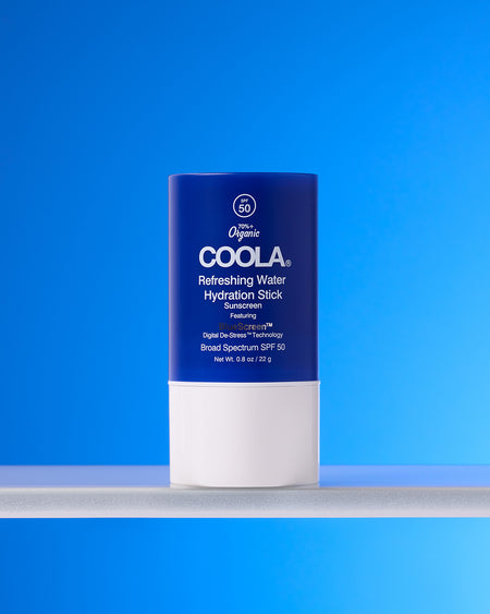 COOLA Refreshing Water Hydration Stick sitting on shelf against blue background