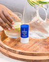 COOLA Refreshing Water Hydration Stick sitting on patio table