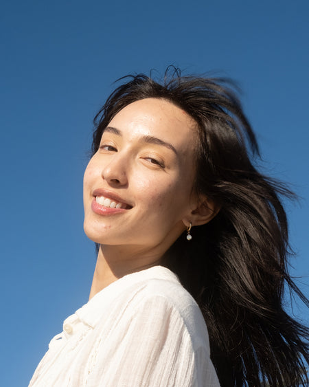 Woman's face with moisturized skin with blue sky background
