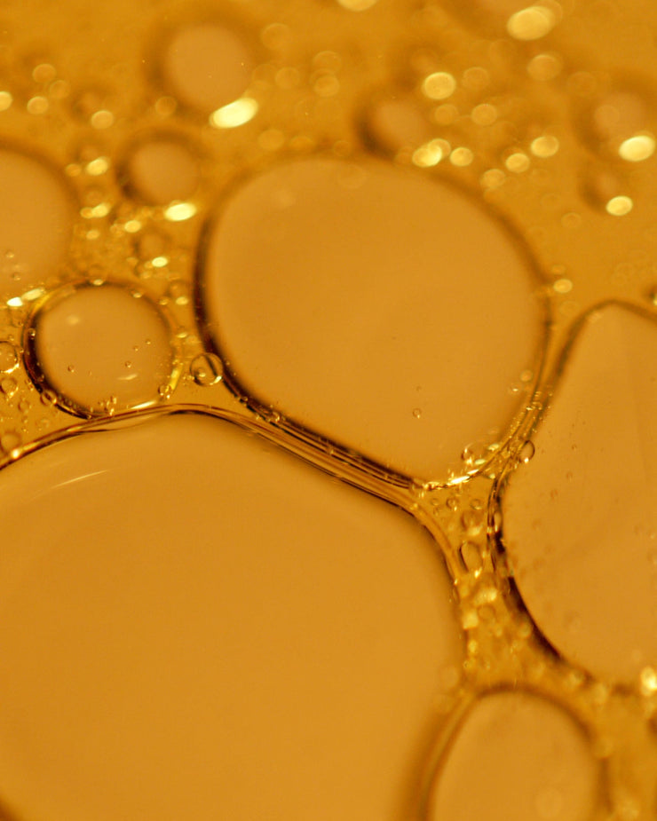 Close up of COOLA Firming Face Oil formula with yellow tint