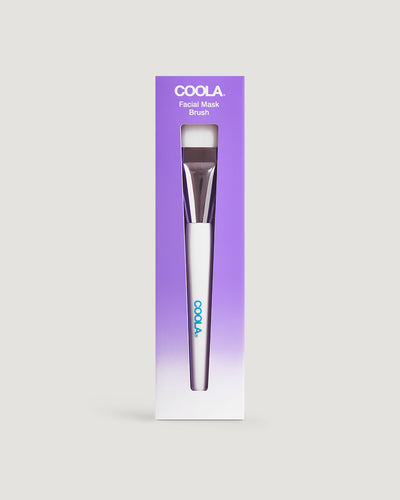 A packaged facial mask brush by COOLA, with the product visible at the bottom of the image.