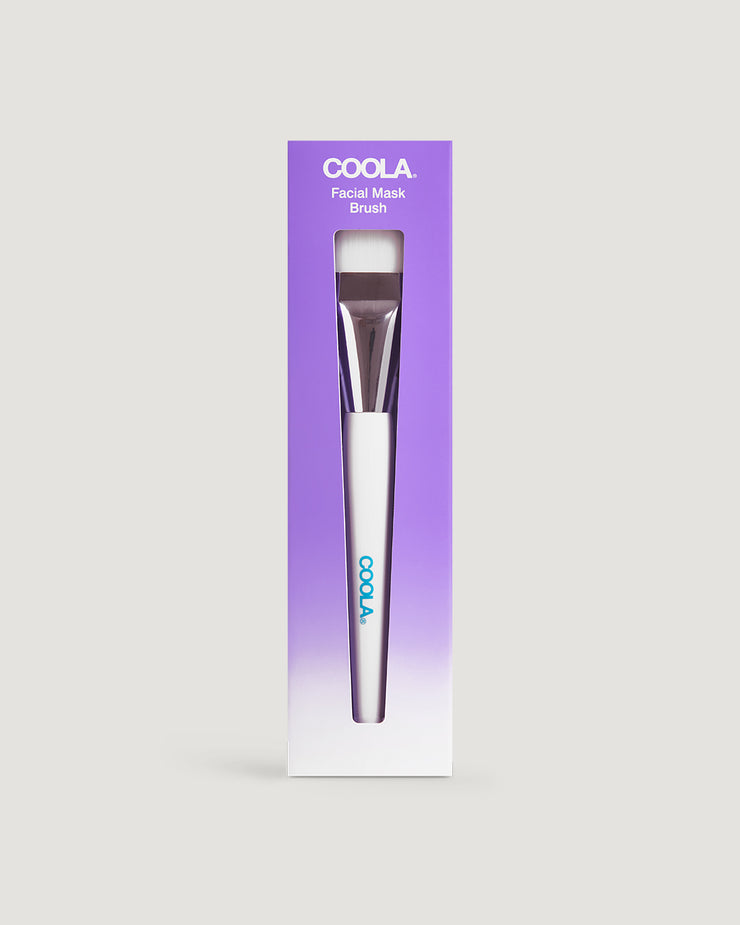 A packaged facial mask brush by COOLA, with the product visible at the bottom of the image.