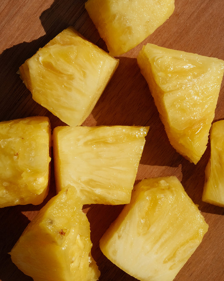 Cubed pineapple pieces on a wooden surface
