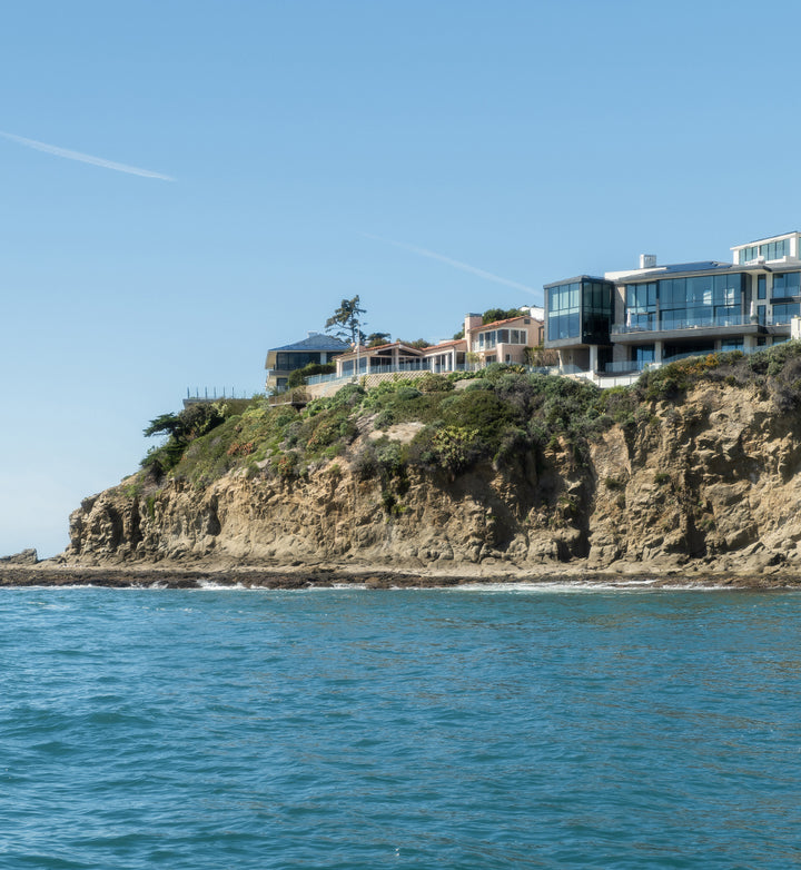 Coastline with houses on top and ocean in foreground.