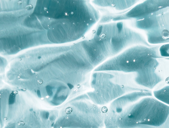 Clear liquid rippling in light with blue background