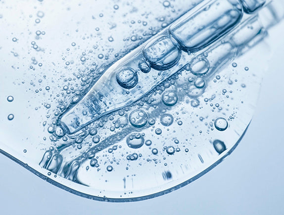 Close-up of clear pipette in clear liquid with small bubbles