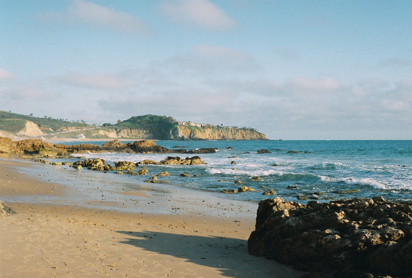 View of coastline with cliff in the background