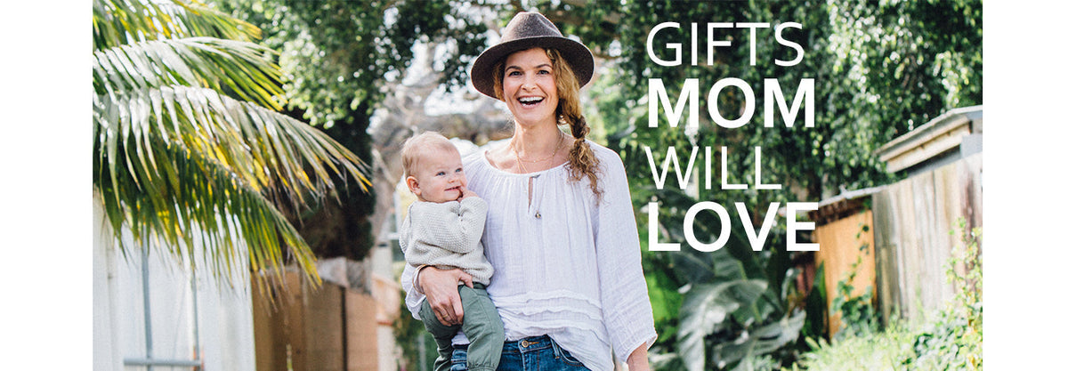 Smiling mother holding a baby on her right hip