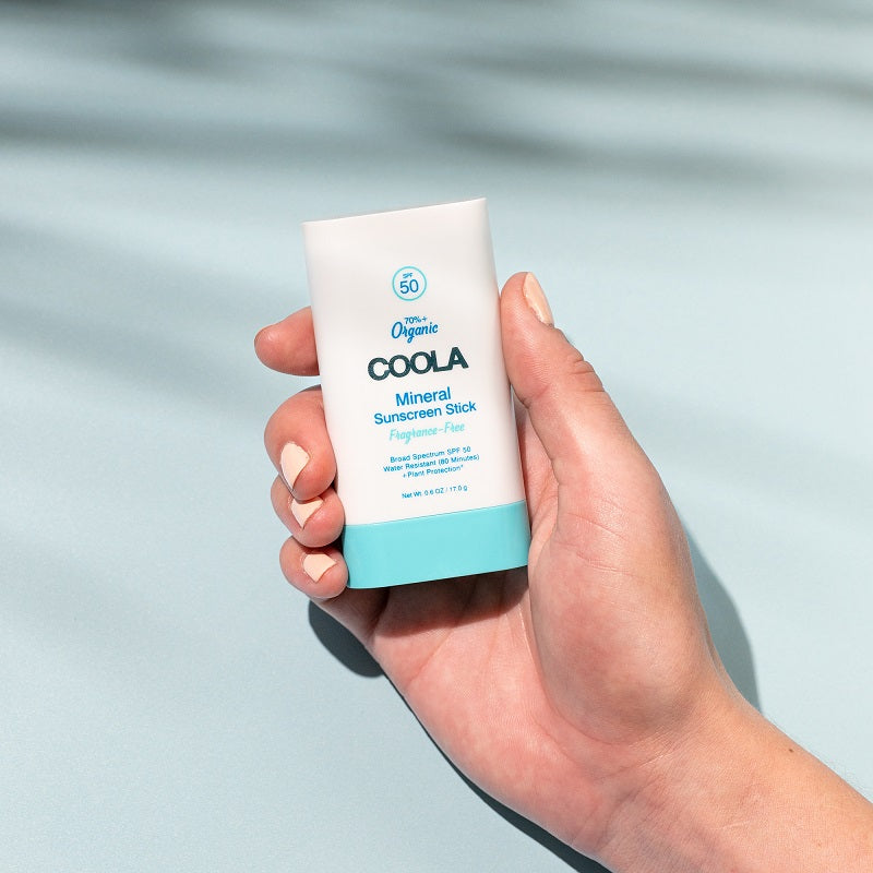 Hand Holding COOLA Mineral Sunscreen Stick