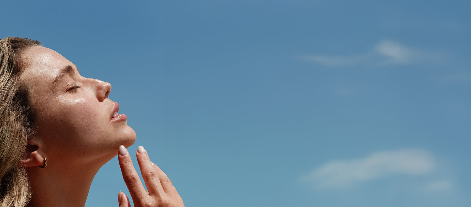 Side view of girl looking up at blue sky