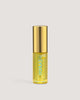 A small, clear glass bottle with a gold lid containing yellow liquid, labeled as Liplux Hydrating Lip Oil.