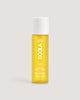 A bottle of COOLA firming body oil mist with a yellow tint and a white cap.