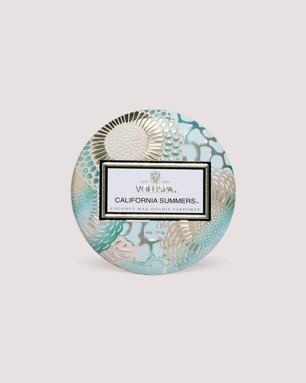 Candle sitting on its side in front of beige background