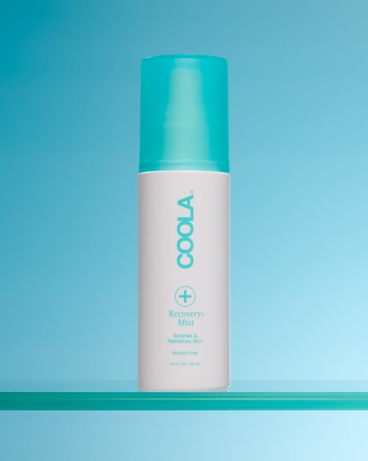 Coola Recovery Mist bottle on a blue background