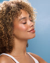 Woman with curly hair against a blue background