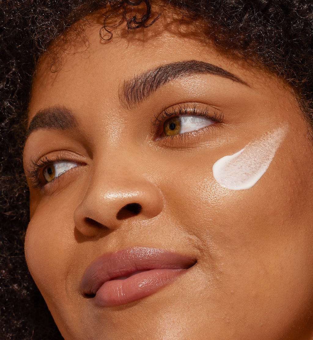 Close-up of woman with white formula swatch on cheek