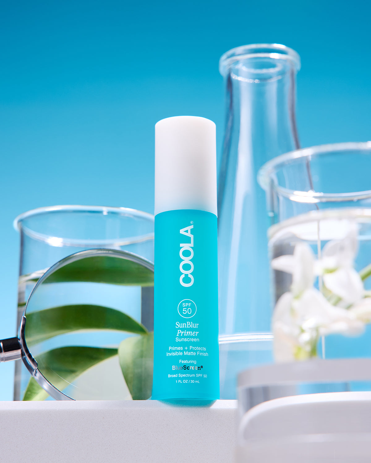 Coola sunscreen bottle with a blue gradient on a blue background