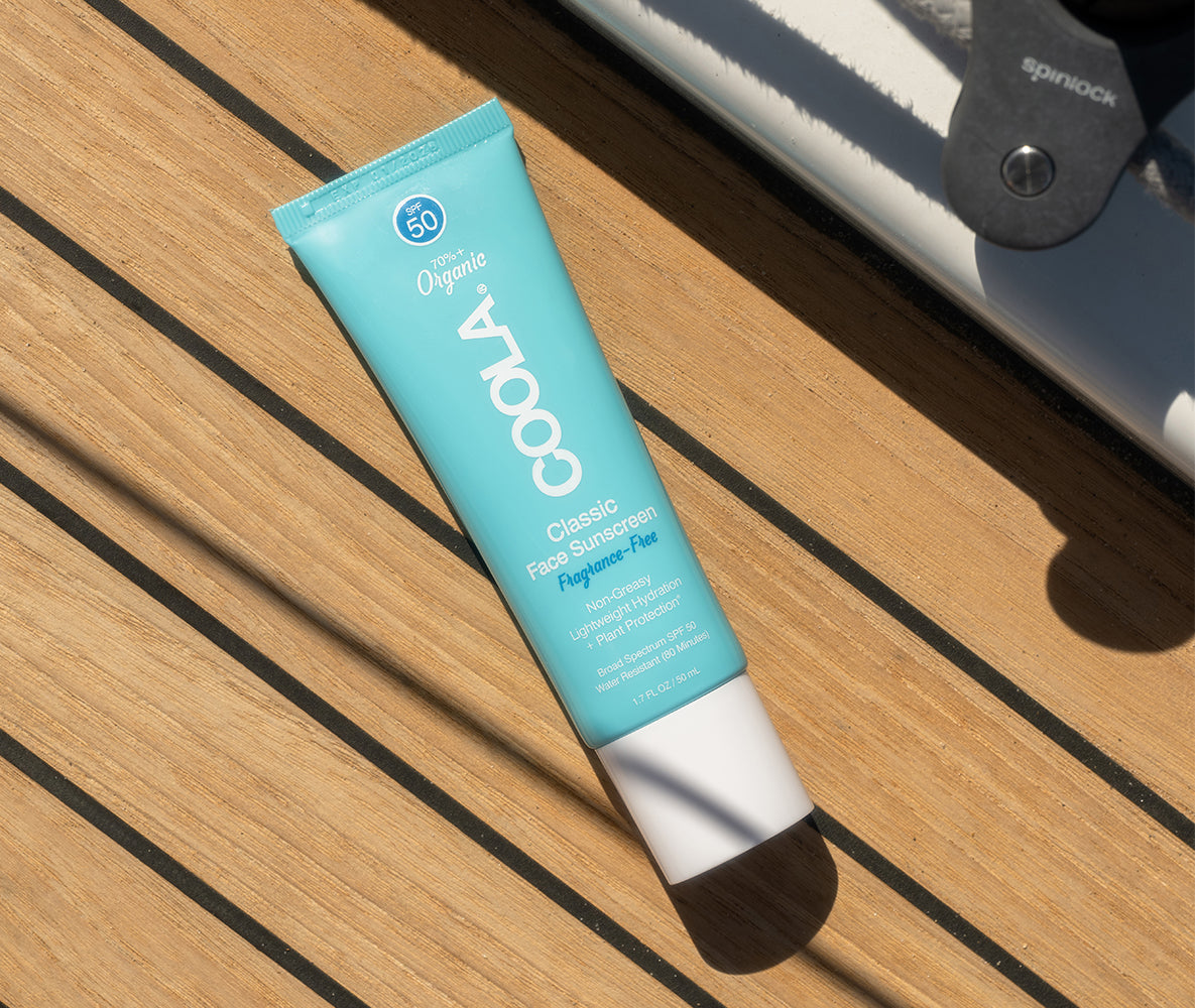 Tube of COOLA Classic Face Sunscreen SPF 50 on a wooden surface