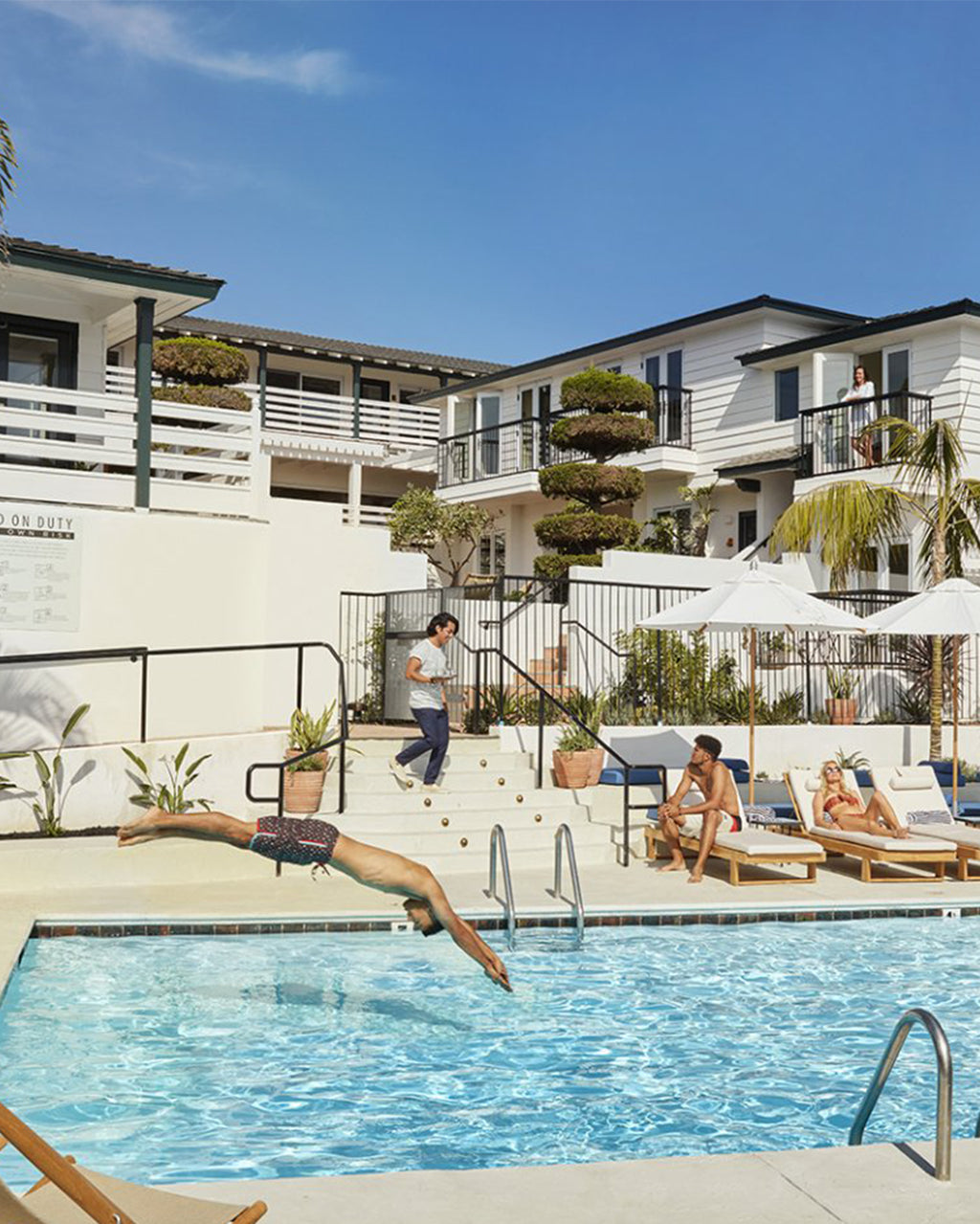 Hotel pool setting with person diving into the pool