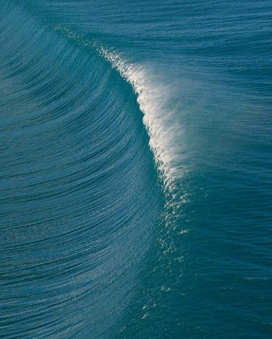 Close-up of a curling wave in deep blue ocean water