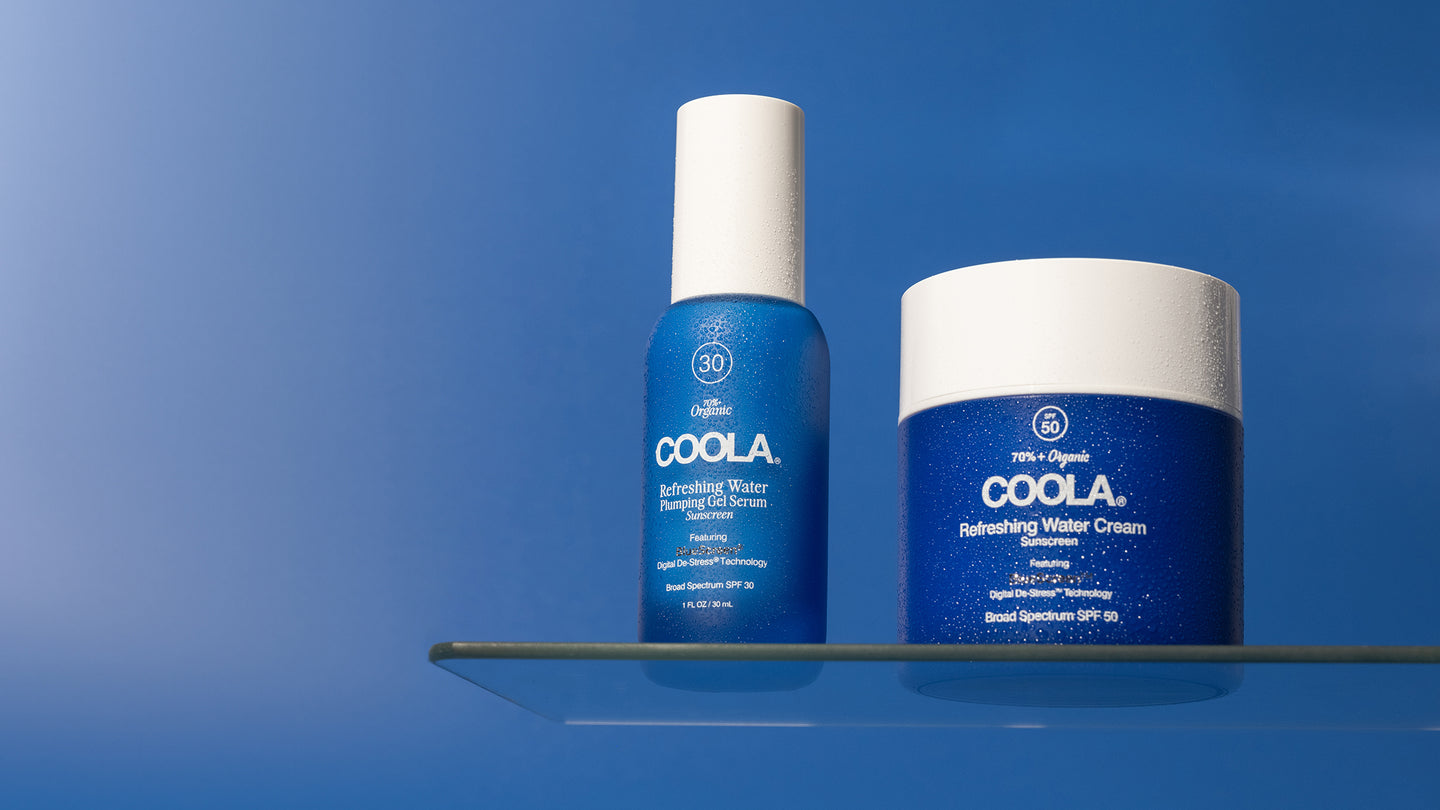 two blue sunscreen products sitting on glass shelf